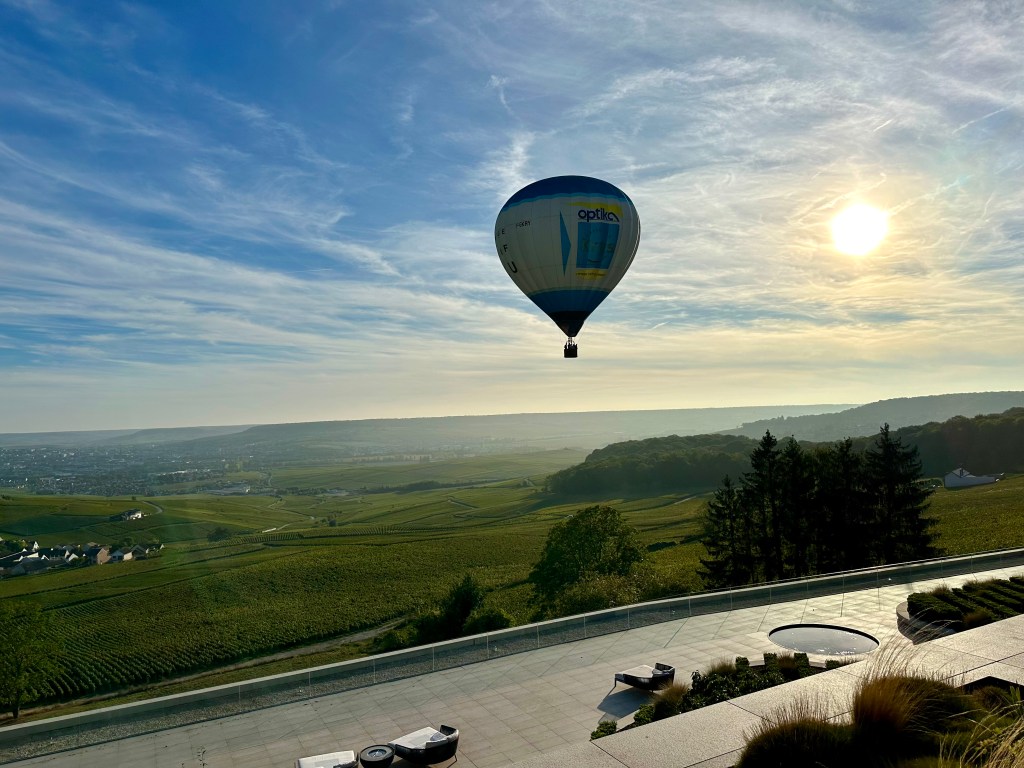 A view of a ballon ascending over the vineyards from the Royal Champagne Hotel terrace.